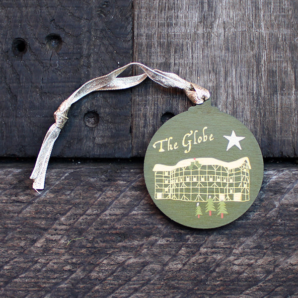 Green round wooden decoration with 'The Globe' and stylised drawing of the Globe Theatre on wooden background