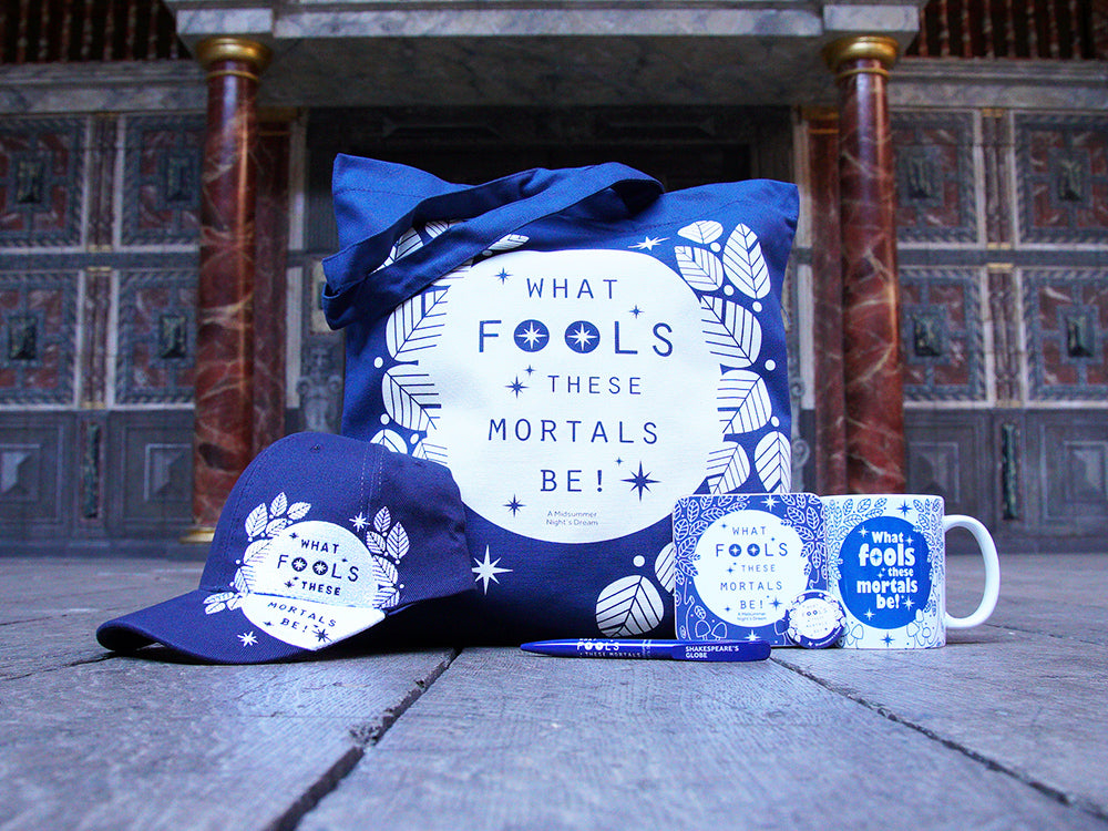 Blue cotton tote back with blue cotton hat, blue pen, blue notepad in foreground all with white graphics and white mug with blue graphics