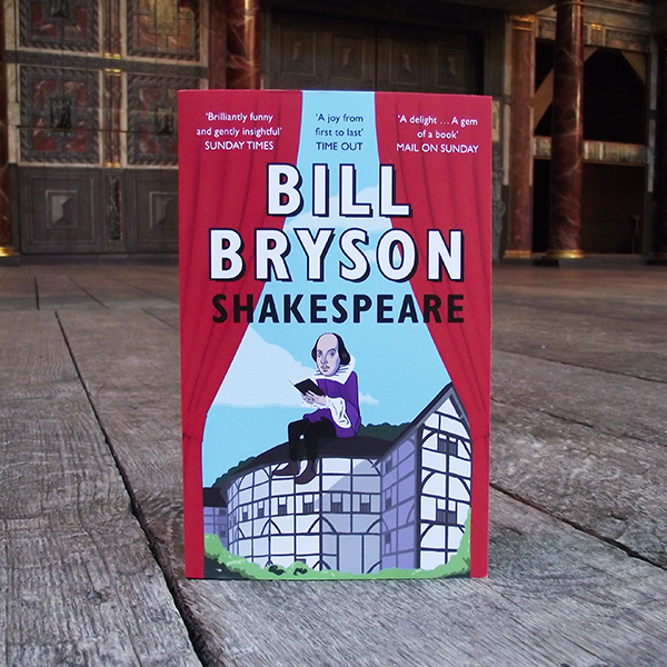 paperback book with a red and blue cover standing on a wooden surface