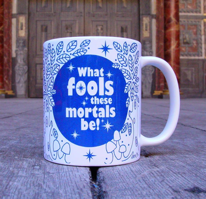 White mug with right handle, featuring blue circular mushroom and leaf motif, sitting on Globe stage