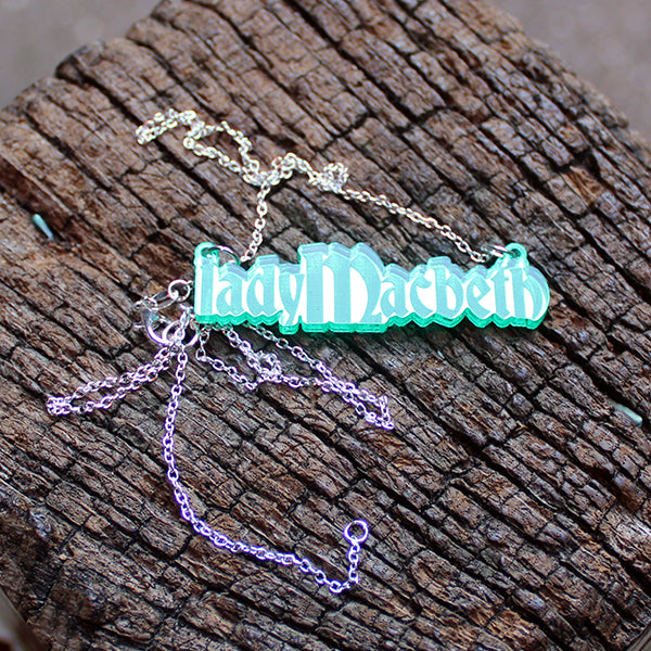 Green acrylic necklace in the shape of letters spelling LadyMacbeth on a silver metal chain
