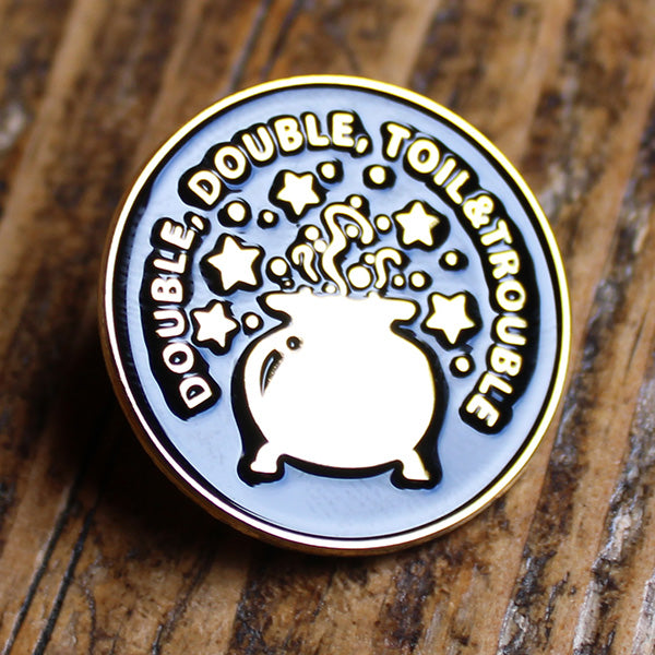 Black and gold coloured round pin badge