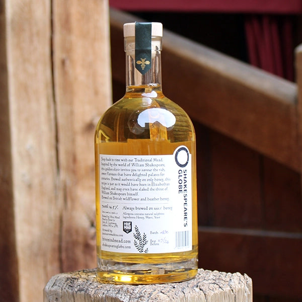 Glass bottle containing an amber liquid with a light coloured stopper and a black and white label