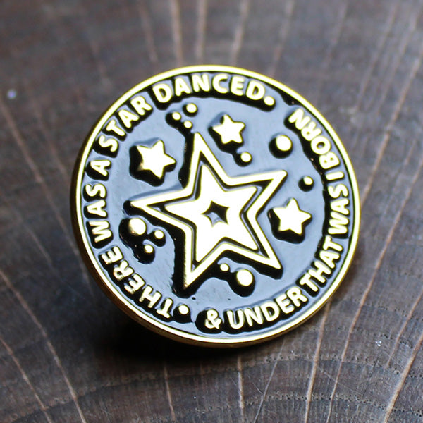 Black and gold coloured round pin badge