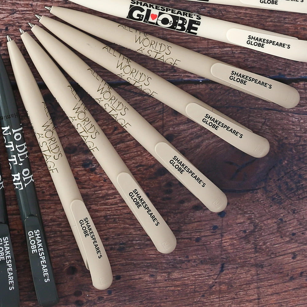 Light grey bioplastic ballpoint pen printed on the barrel with a quote from Shakespeare play, As You Like It, "All the world's a stage" in sage green hand-drawn lettering