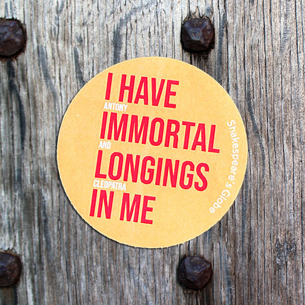 Round yellow sticker with red text on a wooden surface