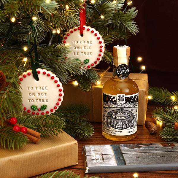 Bottle of mead with Christmas-themed decorations on a wooden surface.