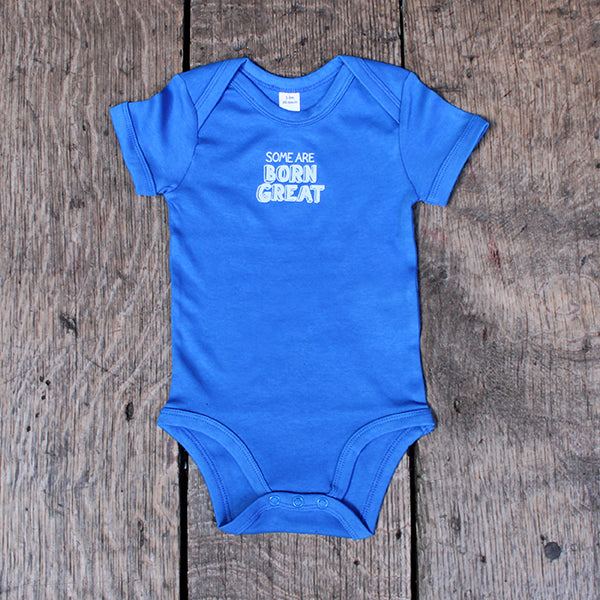 Royal blue cotton baby grow with short sleeve and white graphic text on centre front