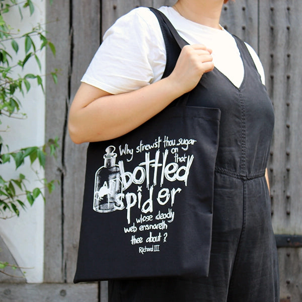 Black cotton 2 handle bag with white graphic text and imagery on front