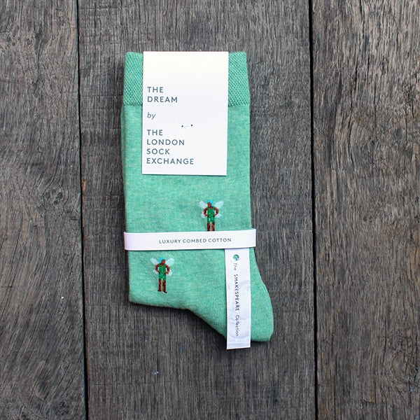 Teal cotton blend sock with repeating pattern of fairy from A Midsummer Night's dream, spaced an inch apart from one another, sock is shown in white card packaging