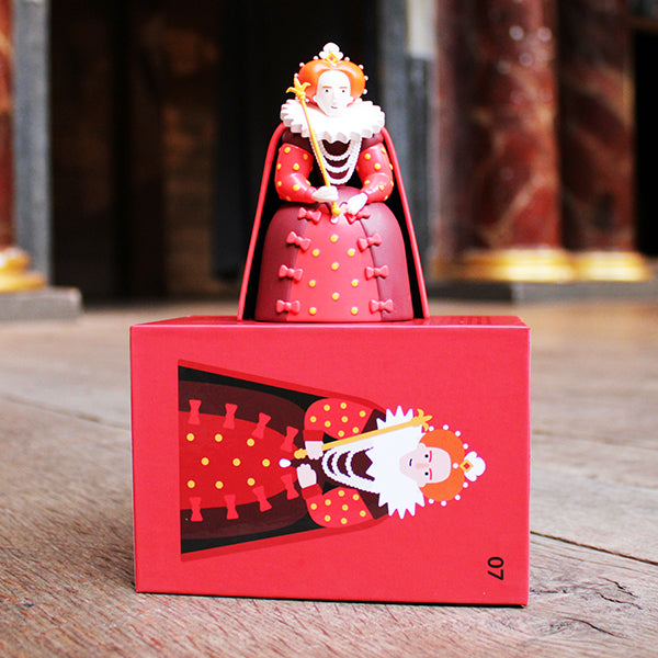 Red figurine with a decorative box on a wooden surface