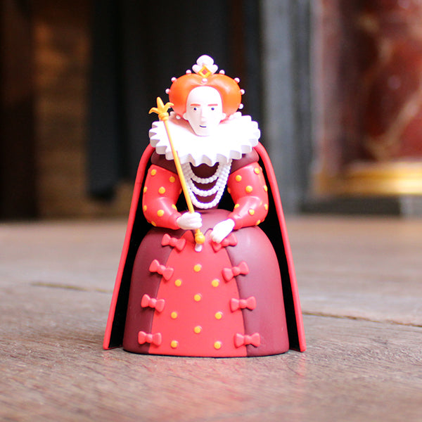 Toy figure of a character in a red outfit with a crown on a wooden surface