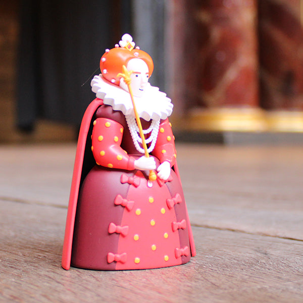 Figurine of a character in a red outfit with a crown on a wooden surface