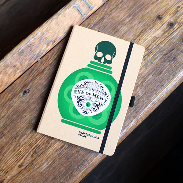 kraft notebook printed on the cover with a green potion bottle with an ornate white label