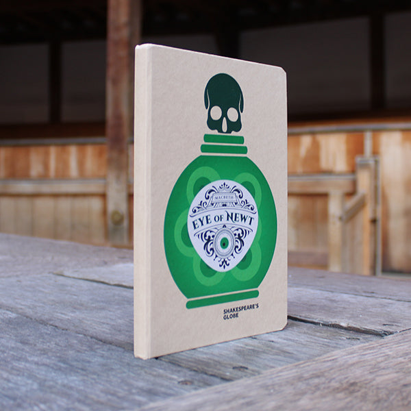 kraft notebook printed on the cover with a green potion bottle with an ornate white label