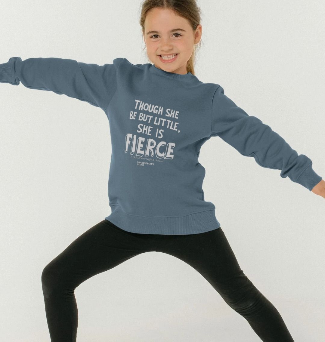 A young girl wearing a mid-blue sweatshirt with a white text print on the front