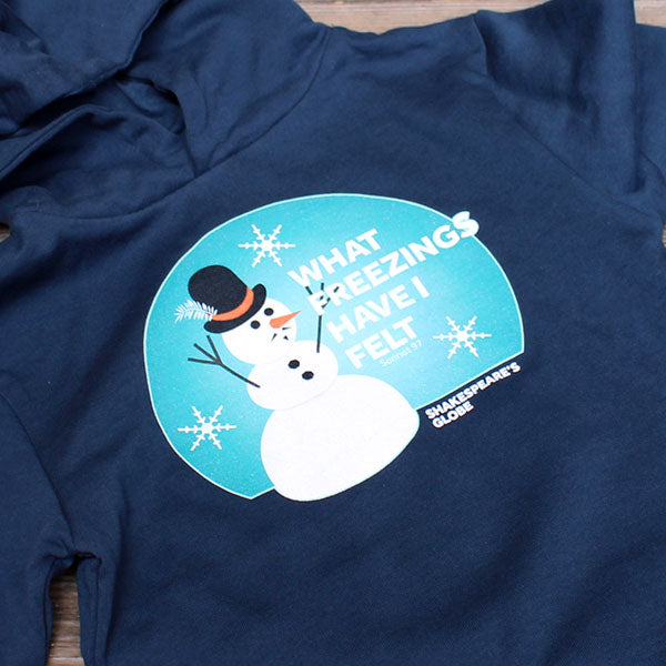 Navy blue t-shirt with a snowman graphic and text on a wooden surface