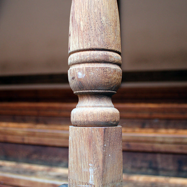 Close-up of a wooden baluster against a blurred wooden background