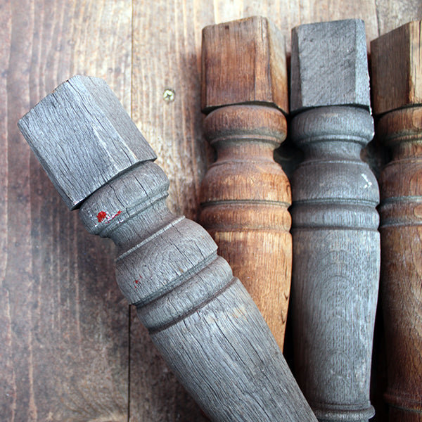 Set of wooden balusters with grayish finish on a wooden surface