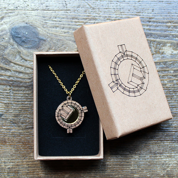 Walnut wood necklace in the shape of an architectural plan on a gold-coloured chain in a kraft paper gift box