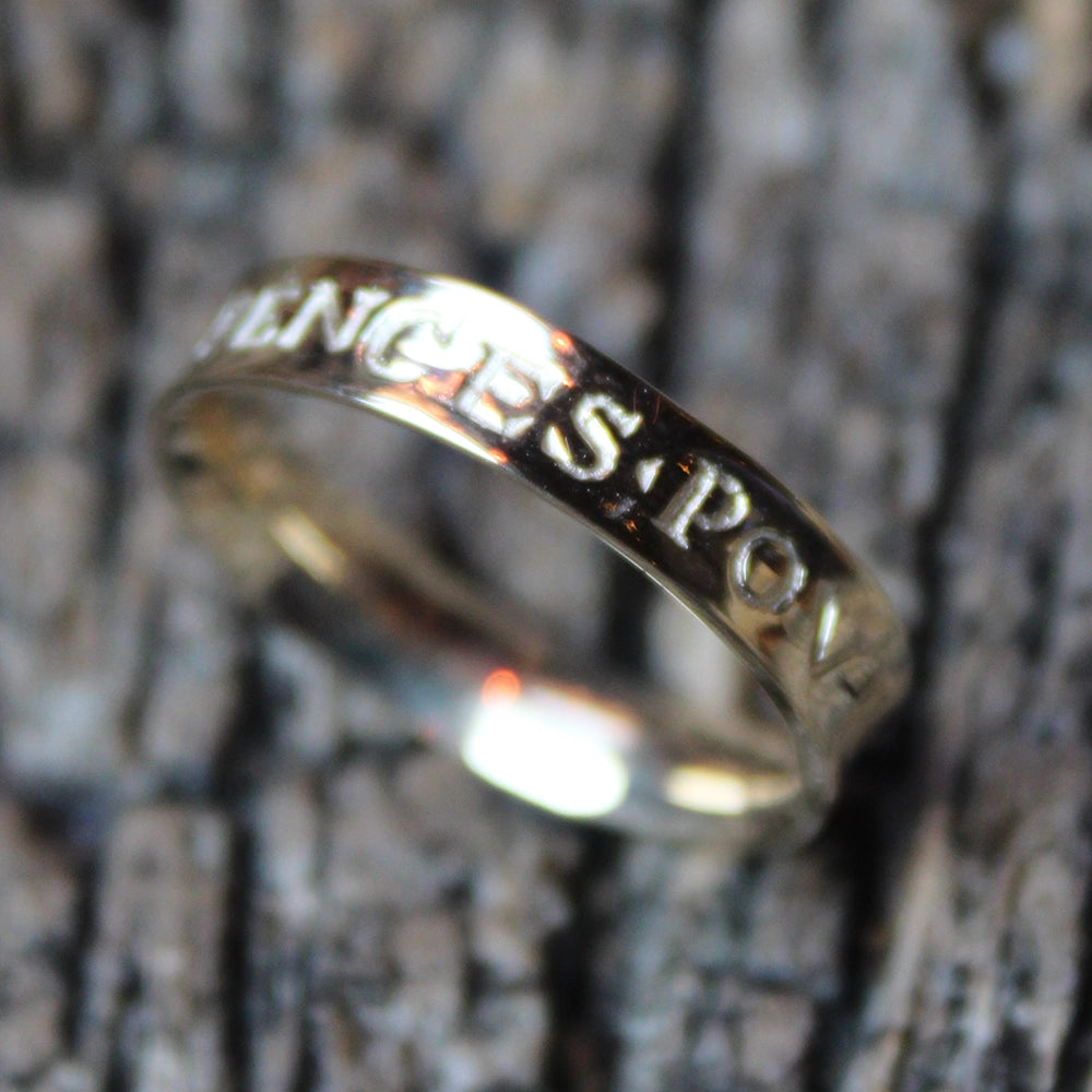 A god ring with engraved letters on a wooden background