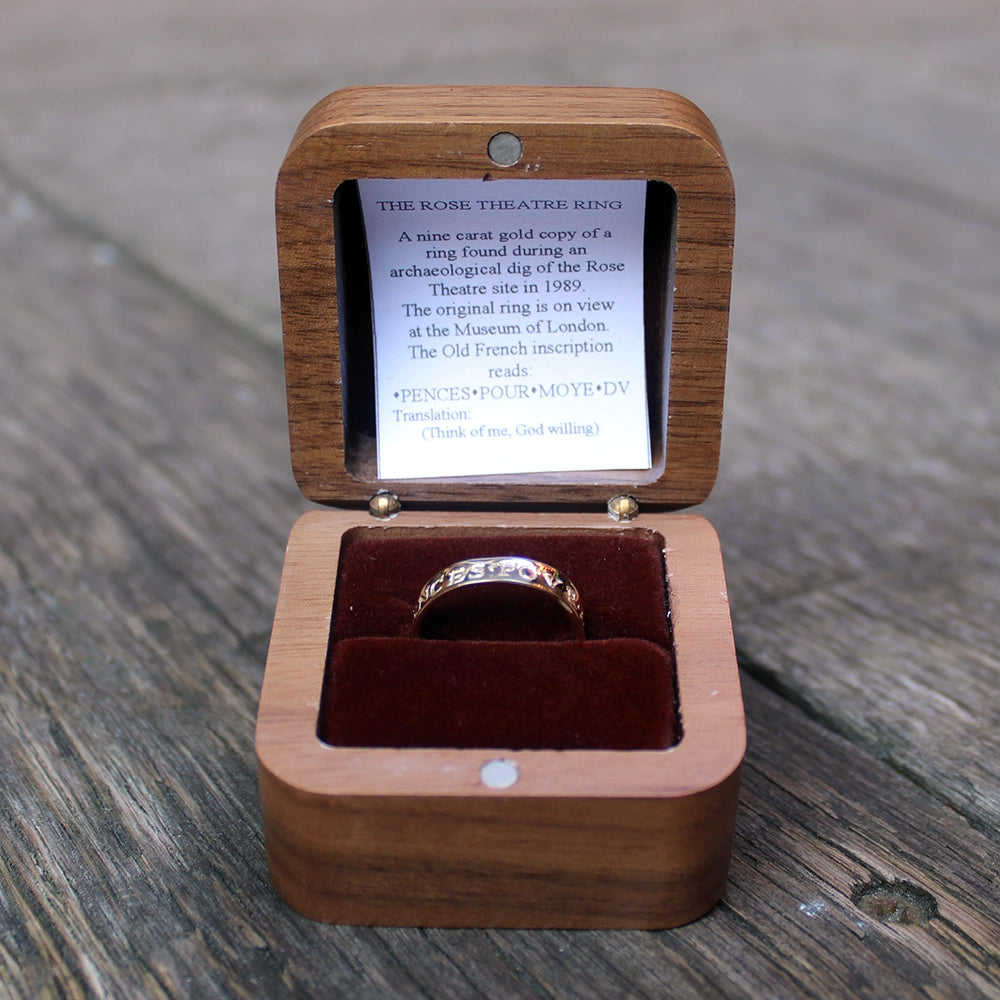 a wooden box with a dark red velvet interior containing a gold ring