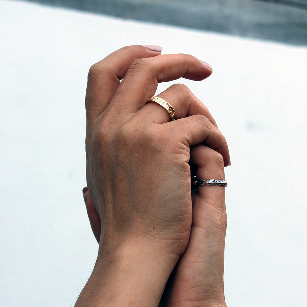 Two hands entwined with rings on the fingers