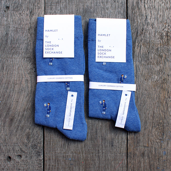 Royal blue cotton blend socks with repeating pattern of Hamlet holding a skull, spaced 1 inch apart, packaged in white card packaging