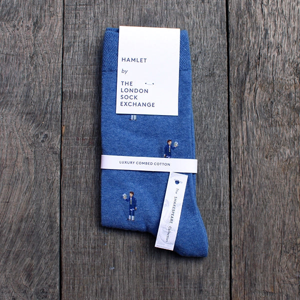 Royal blue cotton blend socks with repeating pattern of Hamlet holding a skull, spaced 1 inch apart, packaged in white card packaging