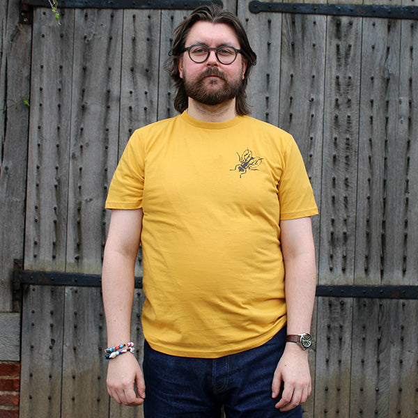 Standard fit cotton t-shirt with black fly graphic on upper left chest on yellow t-shirt