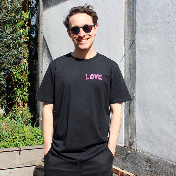 Black t-shirt with hot pink graphic style quote text on upper left chest