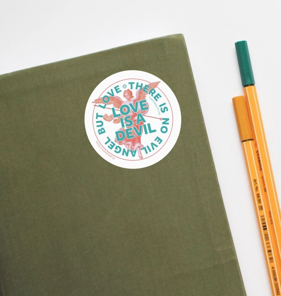 Green notebook with a decorative sticker and two pens on a white background