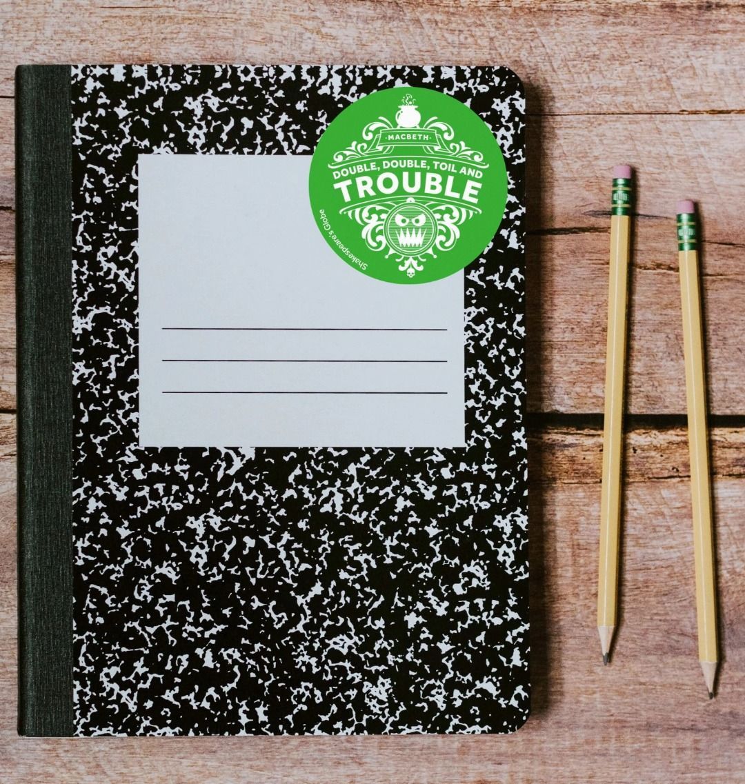 bright green circular sticker with a white print stuck to a black and white notebook