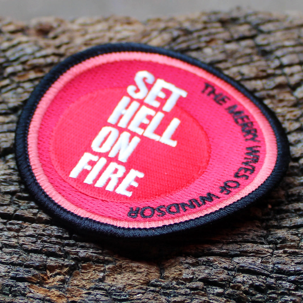 Red and black round embroidered patch on a wooden post