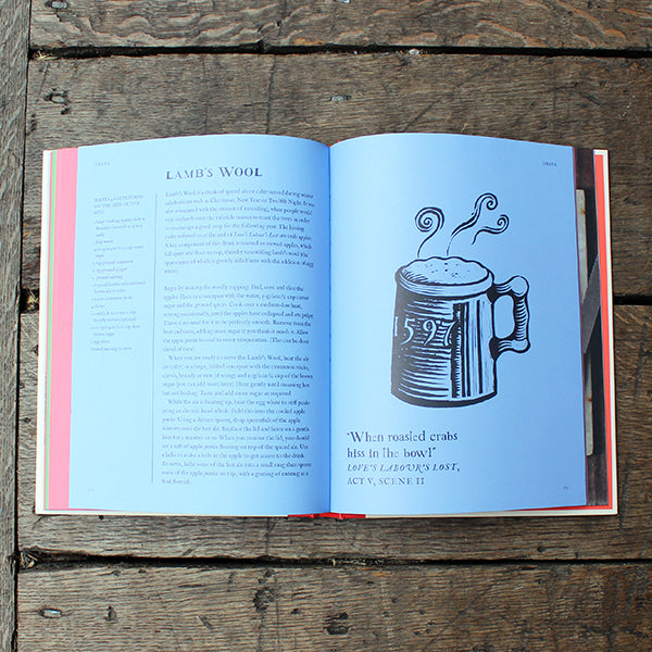 Open book on a wooden surface with a illustration of a mug and text.