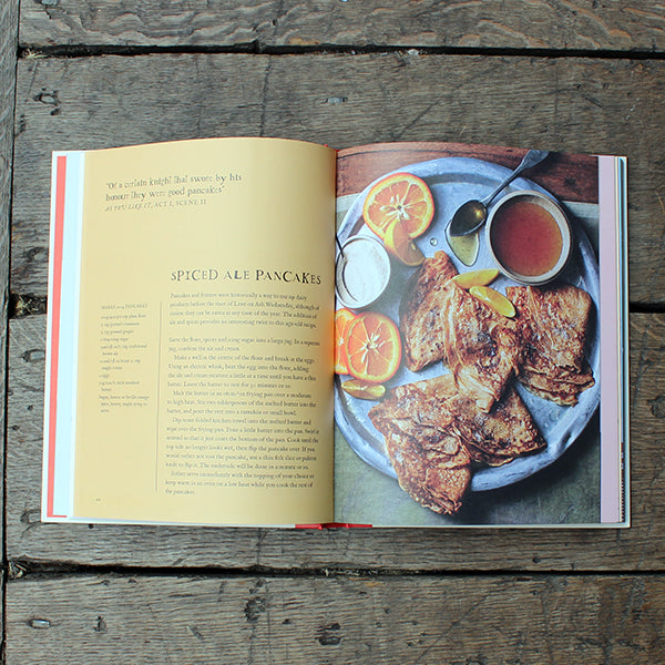 Open cookbook on a wooden surface with a recipe for spiced ale pancakes
