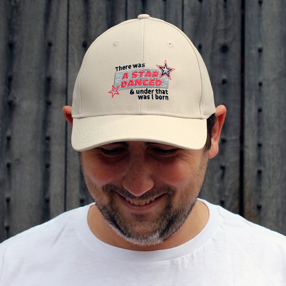 Sand coloured cotton baseball cap with red, black, and silver embroidery on the front