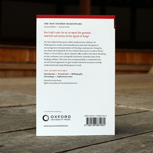 paperback book with a white back cover sitting on a wooden surface
