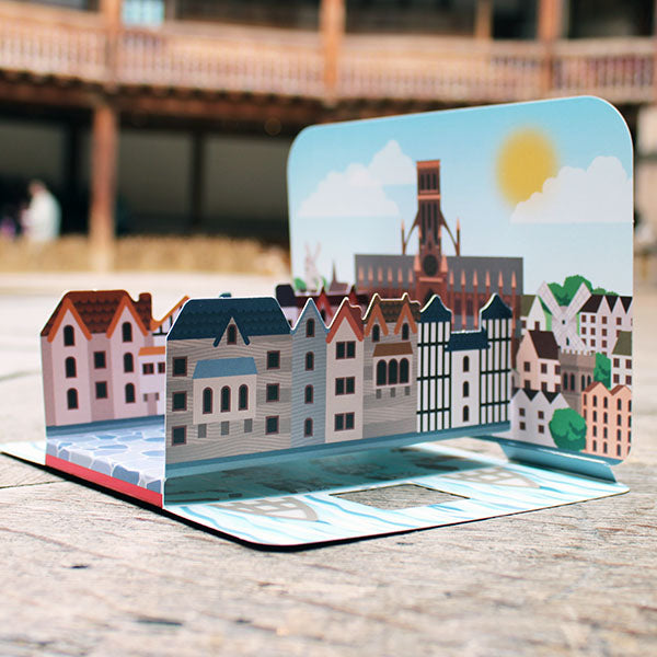 printed card model of the old London Bridge with old St Paul's cathedral behind.