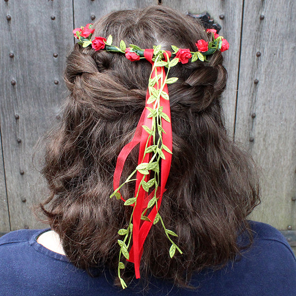 Faux flower, flower crown with greenery and red flowers and ribbons on brunette shoulder length wavy hair