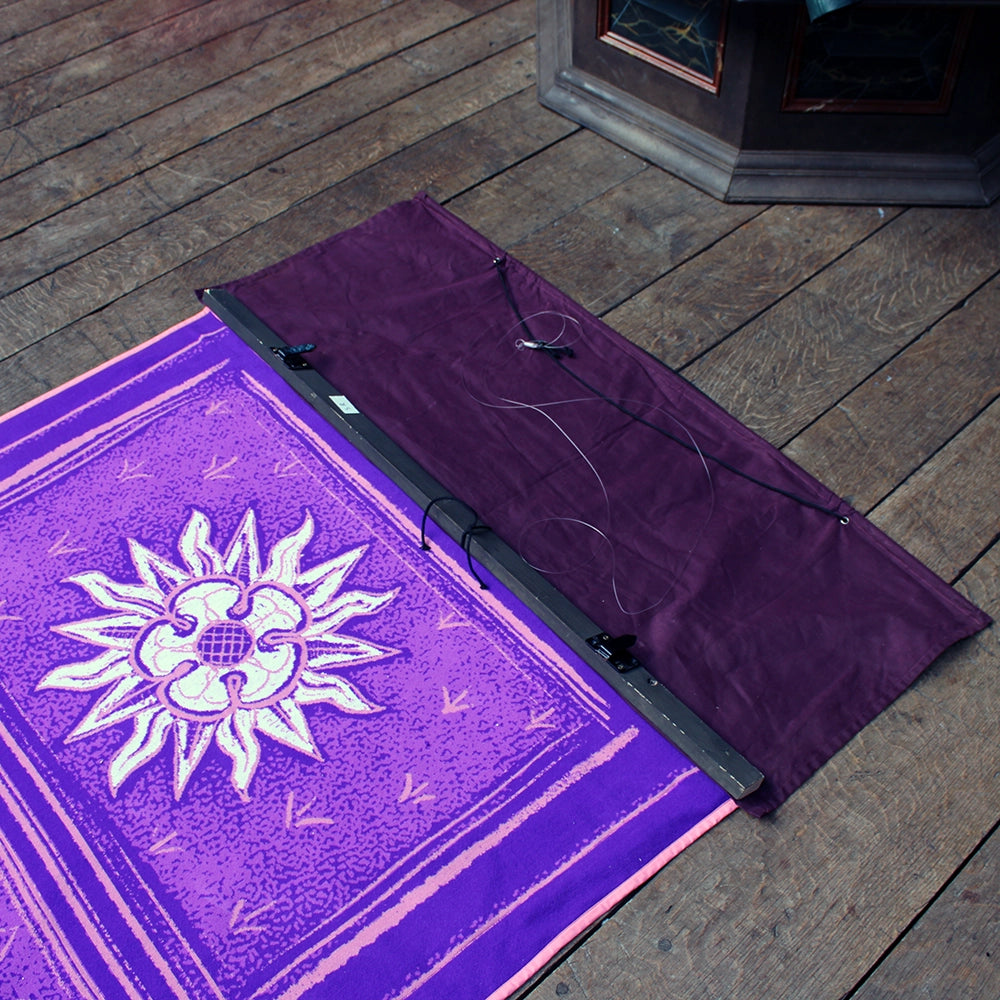 Deep purple fabric banner with white and pink graphics and black weighted bar at the top