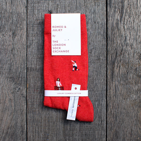 Red cotton blend socks with repeating images of Romeo kneeling and Juliet in her balcony, packaged in white card packaging