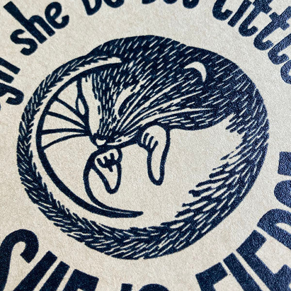 Black illustration of a mouse in a circle of text on a textured beige background.