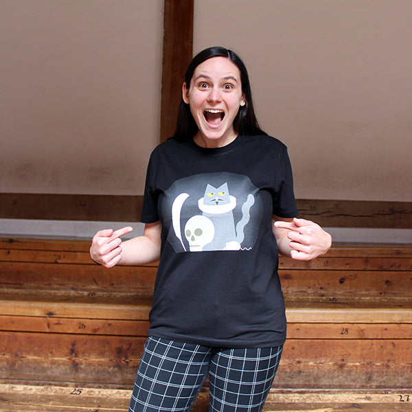 Black round-necked, short-sleeved cotton t-shirt printed with a cartoon image of a grey cat wearing an Elizabethan ruff.