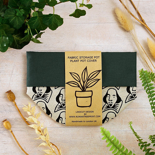 Fabric storage pot on a wooden surface with plants and dried flowers.