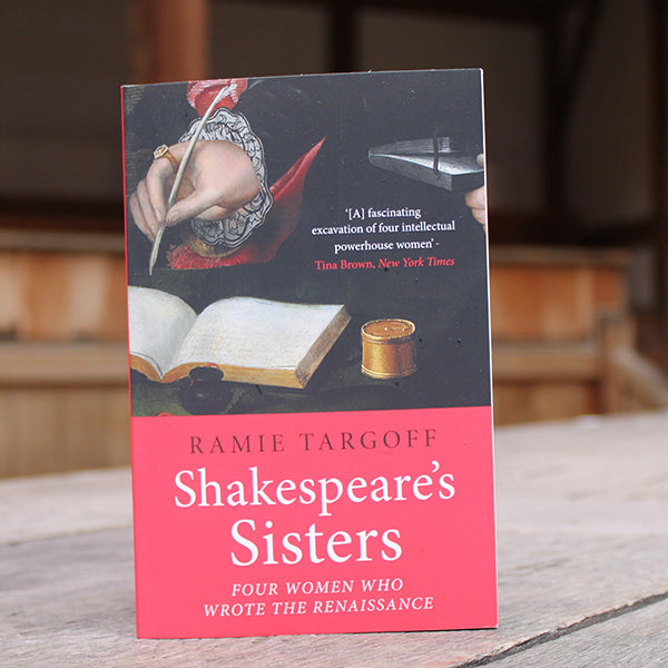Black and red paperback book with white and black text, featuring image of writers hand with quill and ink