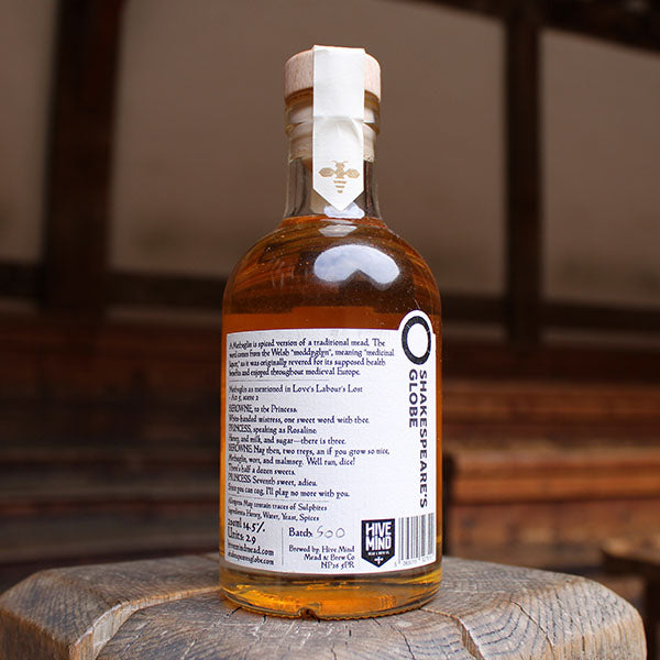 glass bottle containing an amber liquid with a black and white label