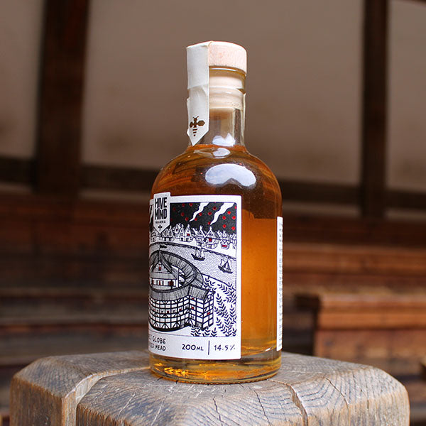glass bottle containing an amber liquid with a black and white label