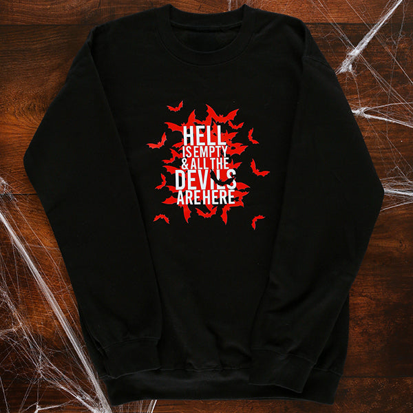 Black sweatshirt with red and white graphic design on a wooden surface