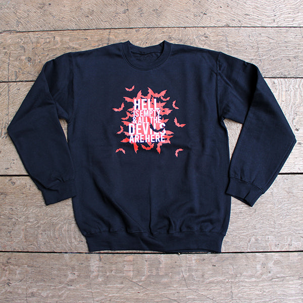 Black sweatshirt with red and white graphic design on a wooden surface